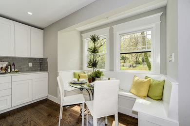 Example of an arts and crafts dark wood floor kitchen design in DC Metro with a farmhouse sink, recessed-panel cabinets, white cabinets, marble countertops, gray backsplash, subway tile backsplash and stainless steel appliances