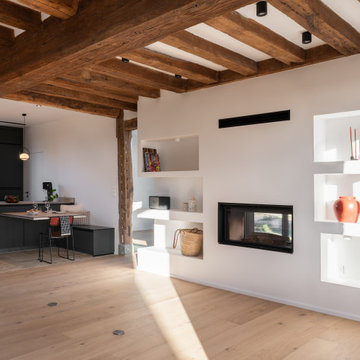 Séjour ouvert sur la cuisine, mur à niches et cheminée