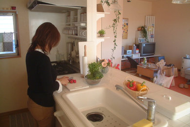 名古屋にある低価格の小さなシャビーシック調のおしゃれなキッチン (シングルシンク、タイルカウンター、白いキッチンパネル、合板フローリング) の写真