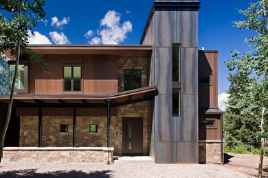 Example of a huge minimalist brown two-story mixed siding flat roof design in Denver