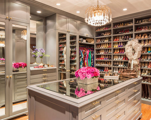 Diseño de vestidor de mujer, clásico, grande, con armarios abiertos, suelo de madera en tonos medios y puertas de armario grises