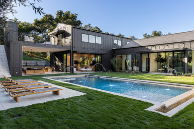 Inspiration for a large contemporary gray two-story concrete fiberboard and board and batten exterior home remodel in Santa Barbara with a tile roof and a gray roof