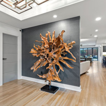 Statement entry with sculptural teak root art against charcoal wallcovering