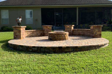 Inspiration for a mid-sized timeless backyard brick patio remodel in Jacksonville with a fire pit and no cover