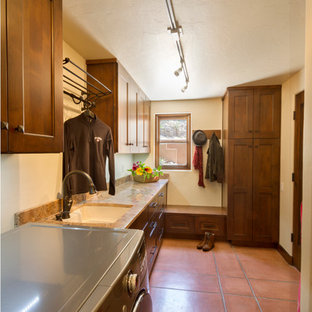 フェニックスのサンタフェスタイルのおしゃれな洗濯室 (落し込みパネル扉のキャビネット、中間色木目調キャビネット、御影石カウンター、ベージュの壁、セラミックタイルの床、左右配置の洗濯機・乾燥機、アンダーカウンターシンク) の写真