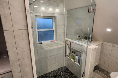 Example of a mid-sized transitional 3/4 white tile and porcelain tile porcelain tile, white floor and single-sink alcove shower design in New York with shaker cabinets, white cabinets, a two-piece toilet, white walls, an undermount sink, quartzite countertops, a hinged shower door, white countertops, a niche and a freestanding vanity