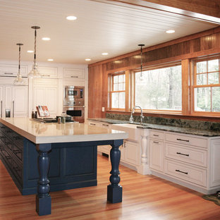 Large farmhouse kitchen pantry pictures - Kitchen pantry - large cottage l-shaped medium tone wood floor and brown floor kitchen pantry idea in Portland Maine with a farmhouse sink, white cabinets, concrete countertops, paneled appliances, an island, raised-panel cabinets, multicolored backsplash and stone slab backsplash