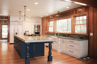 Kitchen pantry - large cottage l-shaped medium tone wood floor and brown floor kitchen pantry idea in Portland Maine with a farmhouse sink, white cabinets, concrete countertops, paneled appliances, an island, raised-panel cabinets, multicolored backsplash and stone slab backsplash