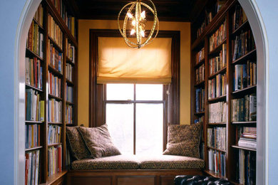 Photo of a mid-sized traditional home office in Boston with a library, dark hardwood floors, brown floor and no fireplace.