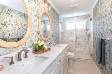 Inspiration for a mid-sized transitional 3/4 beige floor, double-sink and wallpaper alcove shower remodel in Los Angeles with shaker cabinets, white cabinets, an undermount sink, quartz countertops, a hinged shower door, white countertops, a niche and a built-in vanity