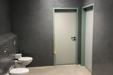 Großes Modernes Badezimmer En Suite mit Wandtoilette mit Spülkasten, grauen Fliesen, grauer Wandfarbe, Betonboden und beigem Boden in Hamburg