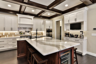 Eat-in kitchen - large transitional l-shaped dark wood floor, brown floor and exposed beam eat-in kitchen idea in St Louis with an undermount sink, recessed-panel cabinets, white cabinets, quartz countertops, glass tile backsplash, stainless steel appliances, an island and white countertops