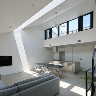 Bild på ett mellanstort funkis allrum med öppen planlösning, med vita väggar, plywoodgolv, en väggmonterad TV och grått golv