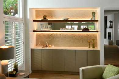 This is an example of a large contemporary single-wall dry bar in Other with no sink, flat-panel cabinets, beige cabinets, engineered stone countertops, beige splashback, mosaic tiled splashback, light hardwood flooring, beige floors and white worktops.