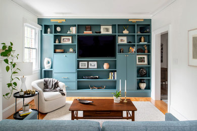 Example of a mid-century modern enclosed medium tone wood floor and brown floor living room design in Raleigh with white walls, no fireplace and a media wall