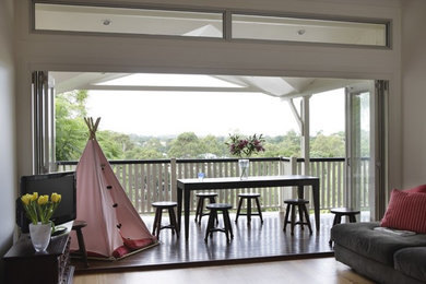Inspiration for a large contemporary balcony in Brisbane with a roof extension and wood railing.