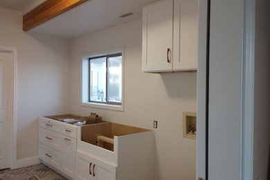 Example of a mid-sized classic single-wall dedicated laundry room design in Other with a farmhouse sink, shaker cabinets and white cabinets