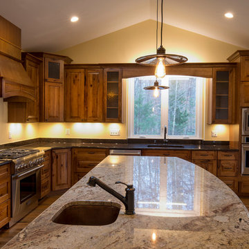 Pendant lighting over large custom island with sink.