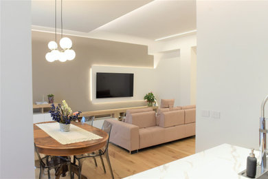 Ispirazione per un soggiorno design con parquet chiaro e TV a parete