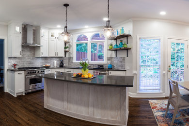 Photo of a mid-sized transitional u-shaped open plan kitchen in Atlanta with an undermount sink, shaker cabinets, white cabinets, quartzite benchtops, grey splashback, subway tile splashback, stainless steel appliances, medium hardwood floors, with island, brown floor and black benchtop.