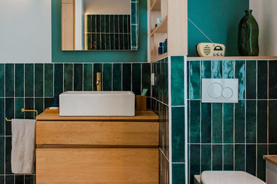 Idée de décoration pour une salle de bain design de taille moyenne avec une douche ouverte, WC suspendus, un carrelage vert, des carreaux de béton, un mur vert, un sol en terrazzo, un lavabo posé, un plan de toilette en bois, un sol multicolore, aucune cabine, des toilettes cachées et meuble simple vasque.