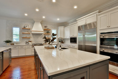 Eat-in kitchen - large modern u-shaped medium tone wood floor and brown floor eat-in kitchen idea in Sacramento with an undermount sink, shaker cabinets, white cabinets, quartz countertops, white backsplash, porcelain backsplash, stainless steel appliances, two islands and white countertops