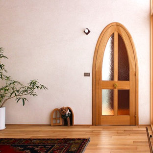 札幌の片開きドアアジアンスタイルのおしゃれな玄関 (白い壁、淡色無垢フローリング、淡色木目調のドア、ベージュの床) の写真