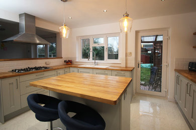 Design ideas for a medium sized country l-shaped kitchen/diner in West Midlands with a double-bowl sink, shaker cabinets, grey cabinets, wood worktops, white splashback, porcelain splashback, ceramic flooring and an island.