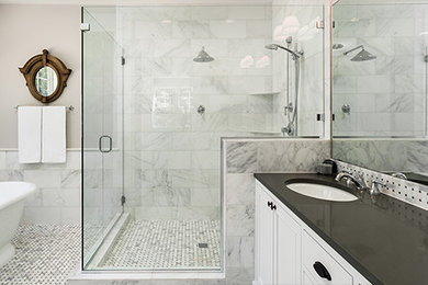 Inspiration for a large transitional master bathroom in Chicago with shaker cabinets, white cabinets, a freestanding tub, a corner shower, white tile, marble, beige walls, marble floors, an undermount sink, grey floor and a hinged shower door.