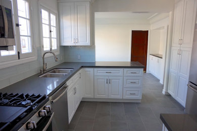 Example of a mid-sized transitional l-shaped cement tile floor and gray floor enclosed kitchen design in Los Angeles with a double-bowl sink, recessed-panel cabinets, white cabinets, marble countertops, blue backsplash, subway tile backsplash, stainless steel appliances, no island and gray countertops