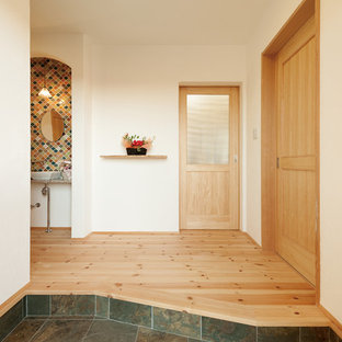 他の地域のエクレクティックスタイルのおしゃれな玄関ホール (白い壁、グレーの床) の写真