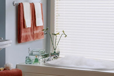 Example of a large transitional master beige tile light wood floor freestanding bathtub design in Raleigh with a two-piece toilet, a drop-in sink, tile countertops, beaded inset cabinets, beige cabinets and blue walls