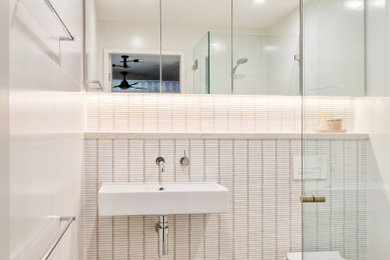 Inspiration for a contemporary bathroom in Sydney with a corner shower, white tile, mosaic tile, a wall-mount sink, grey floor and a single vanity.