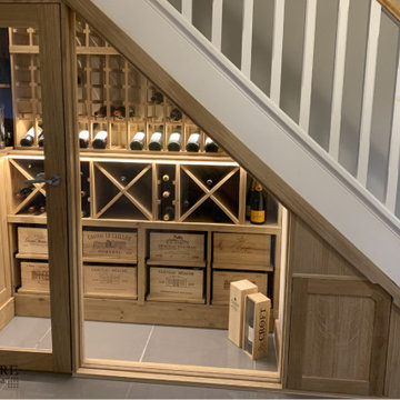 Bespoke under stairs wine room with glass front in Oxfordshire