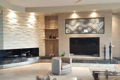 Example of a mid-sized transitional limestone floor and beige floor living room design in Orange County with gray walls, a ribbon fireplace, a stone fireplace and a wall-mounted tv