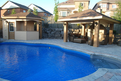 Inspiration for a mid-sized transitional full sun backyard concrete paver retaining wall landscape in Toronto.
