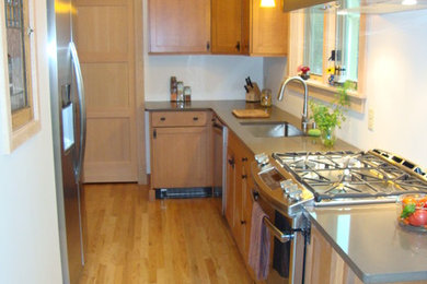 Inspiration for a small craftsman l-shaped medium tone wood floor enclosed kitchen remodel in Boston with a single-bowl sink, shaker cabinets, light wood cabinets, quartz countertops, stainless steel appliances and no island