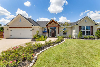 Example of an arts and crafts white one-story brick house exterior design in Austin with a shingle roof