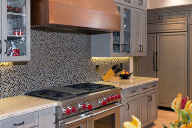 Mid-sized arts and crafts galley light wood floor open concept kitchen photo in Orange County with an undermount sink, raised-panel cabinets, gray cabinets, granite countertops, multicolored backsplash, mosaic tile backsplash, paneled appliances and an island