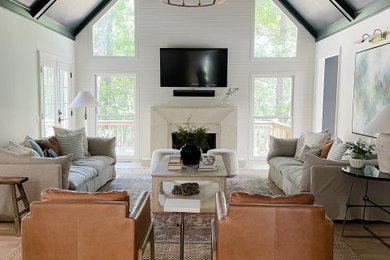 Transitional light wood floor, vaulted ceiling and shiplap wall living room photo in Atlanta with white walls and a stone fireplace