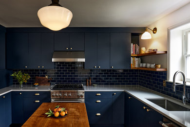 フィラデルフィアにある高級な小さなトランジショナルスタイルのおしゃれなキッチン (アンダーカウンターシンク、フラットパネル扉のキャビネット、青いキャビネット、クオーツストーンカウンター、青いキッチンパネル、セラミックタイルのキッチンパネル、シルバーの調理設備、濃色無垢フローリング、グレーのキッチンカウンター) の写真