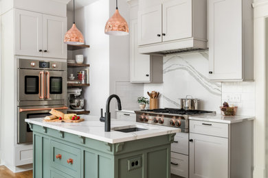 Inspiration for a transitional l-shaped kitchen remodel in Atlanta with granite backsplash, black appliances and two islands