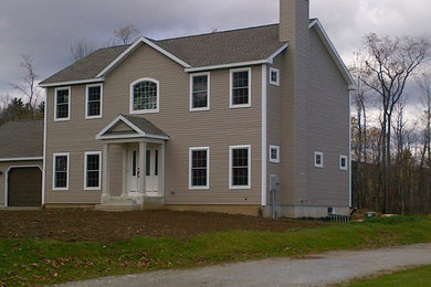 Large arts and crafts beige two-story wood exterior home photo in Boston with a shingle roof
