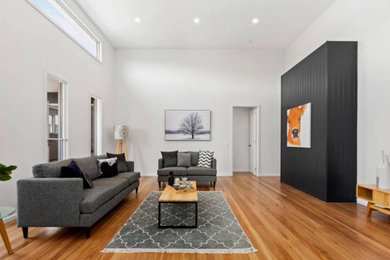 Contemporary living room in Melbourne with medium hardwood floors.