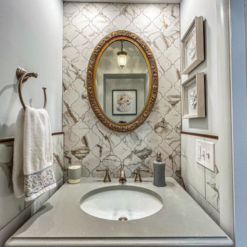 Powder Room Featuring Tiled Perimeter Walls and Accent Tile Behind the Vanity