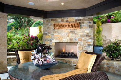 Example of a large trendy backyard concrete paver patio design in Orange County with a fire pit and no cover