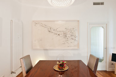 Foto di una sala da pranzo minimal con pareti bianche e parquet scuro