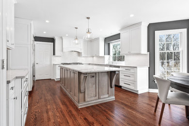 Eat-in kitchen - large transitional u-shaped medium tone wood floor and brown floor eat-in kitchen idea in Chicago with a single-bowl sink, shaker cabinets, white cabinets, quartzite countertops, white backsplash, porcelain backsplash, stainless steel appliances, an island and gray countertops