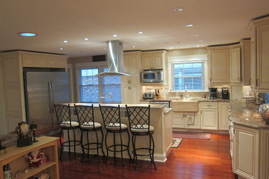 Photo of a contemporary eat-in kitchen in Chicago with a farmhouse sink, recessed-panel cabinets, white cabinets and granite benchtops.