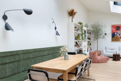 Cette photo montre une salle à manger ouverte sur le salon tendance avec parquet clair et un sol beige.